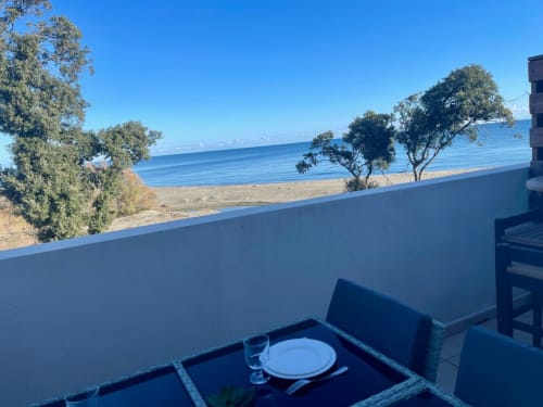 Beachfront terrace at Marina di Bravone, Corsica with sea view, dining table, and Mediterranean landscape