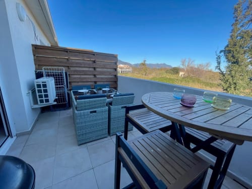 Rooftop terrace with dining table, lounge seating, and mountain views at Résidence Marina di Bravone, Linguizzetta