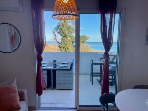 Marina di Bravone beachfront apartment with sea view terrace, dining area, and woven pendant light