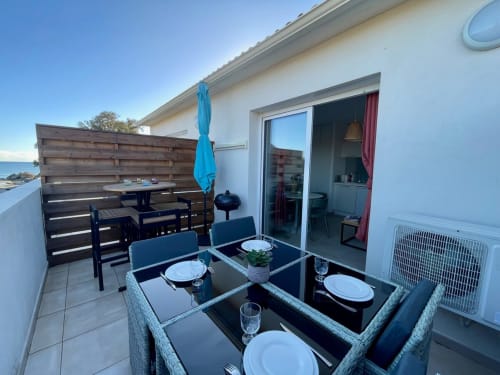 Marina di Bravone terrace with dining table, sea view, and direct beach access in Linguizzetta, Corsica
