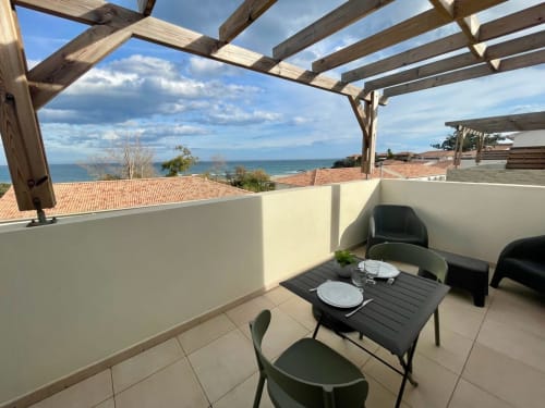 Terrazza fronte mare della Résidence Marina di Bravone con zona pranzo, vista sul mare e pergolato in Corsica