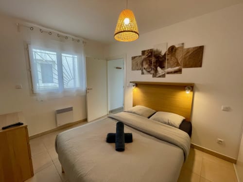 Cozy beachfront apartment at Résidence Marina di Bravone with double bed, yellow headboard, and modern amenities in