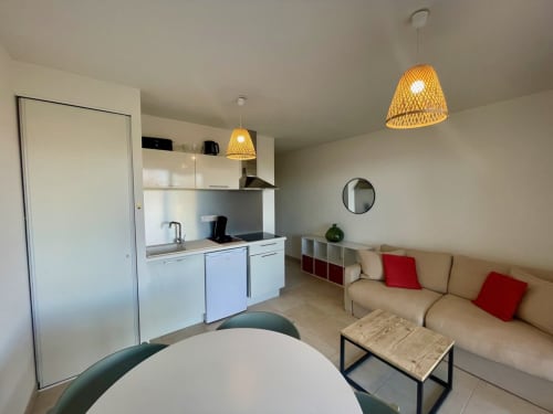 Modern studio apartment at Résidence Marina di Bravone in Linguizzetta with open-plan kitchen, living area, and red accent