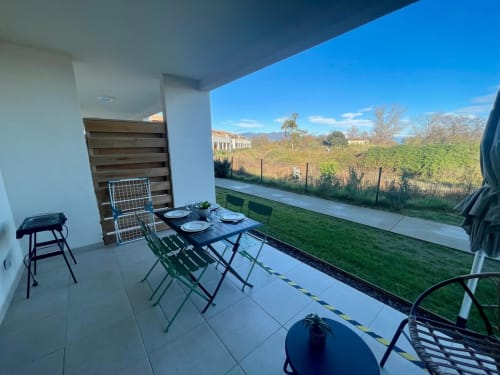 Modern terrace at Résidence Marina di Bravone with dining table, sea views, and vineyard landscape in Linguizzetta, Corsica