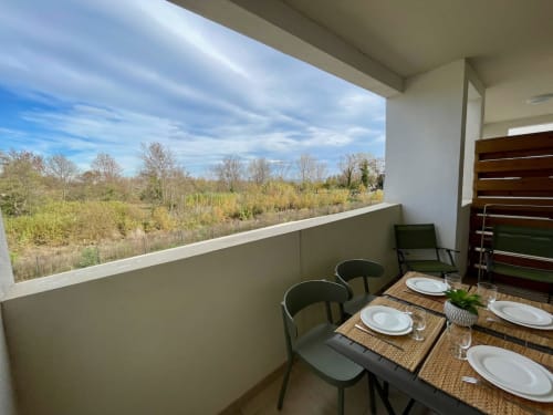 Marina di Bravone beachfront apartment balcony with dining setup overlooking forest landscape