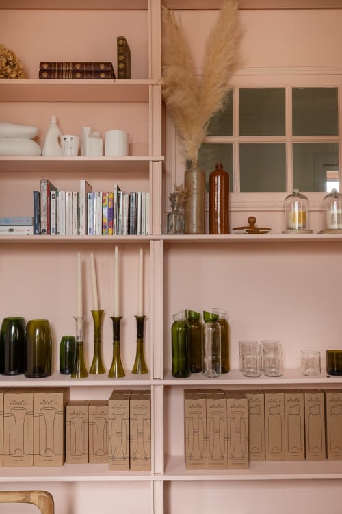 Étagères roses de la maison d'hôtes Moulin Moulin avec livres, verrerie, bougies et herbes de pampa à Dannes