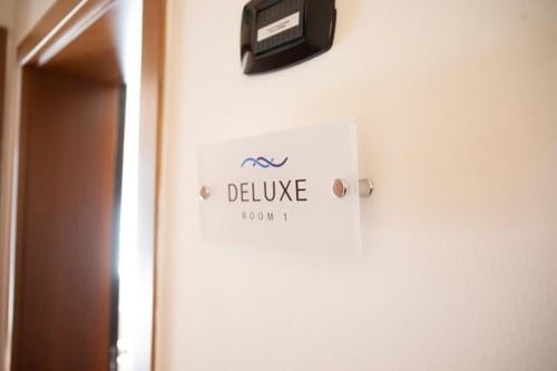 Cartello della porta della Deluxe Room 1 presso l'hotel Mas Collection a Bari, Italia