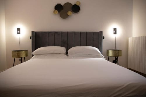 Modern Superior Double Room at Mas Collection hotel in Bari with elegant charcoal headboard, crisp white linens, and brass