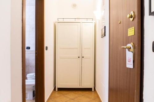 Hallway with cream-colored closet and wooden doors in Mas Collection Bari apartment, with bathroom and entrance visible