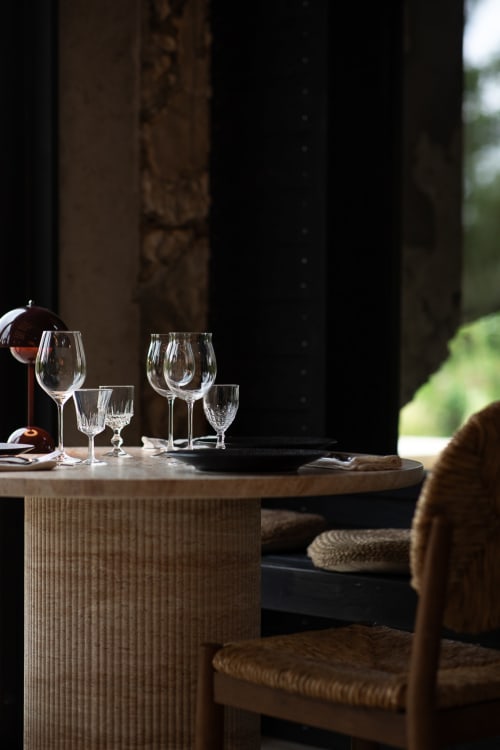 Élégant cadre de salle à manger au Moulin Moulin B&B à Dannes avec verres à vin et chaises en rotin près des fenêtres