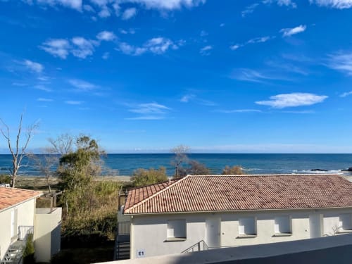 Vista costiera della Résidence Marina di Bravone con edifici bianchi, tetti in cotto e il Mar Mediterraneo a Linguizzetta