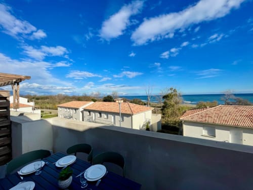 Terrazza dell'appartamento Résidence Marina di Bravone con vista mare, zona pranzo e paesaggio costiero a Linguizzetta