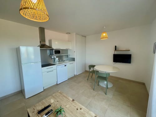 Cucina e zona living moderna della Résidence Marina di Bravone a Linguizzetta con elettrodomestici bianchi e tavolo da pranzo