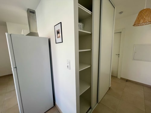 Espace cuisine moderne de la Résidence Marina di Bravone avec réfrigérateur, rangements et décoration épurée à Linguizzetta