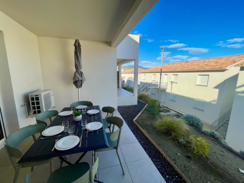 Terrasse couverte avec table à manger à la Résidence Marina di Bravone, Linguizzetta, vue sur les bâtiments côtiers et les montagnes