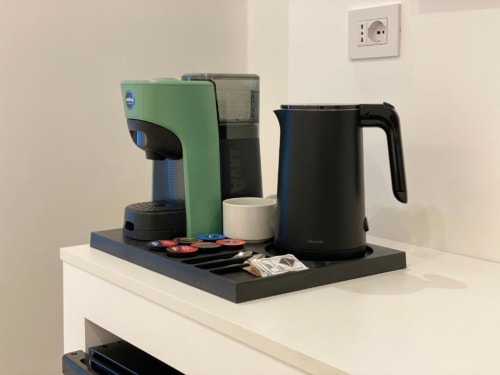 Caffettiera verde, bollitore elettrico e capsule di caffè su vassoio nell'Appartamento Superior della Collezione Mas