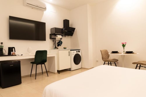 Moderno appartamento a Bari con letto, angolo cottura, lavatrice, scrivania, zona pranzo e TV a schermo piatto
