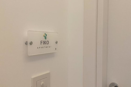 Targhetta dell'appartamento FIKO su parete bianca presso l'hotel Mas Collection Bari