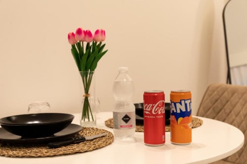 Elegante mise en place nella sala da pranzo di Mas Collection Bari con tulipani rosa, bevande e servizi da tavola