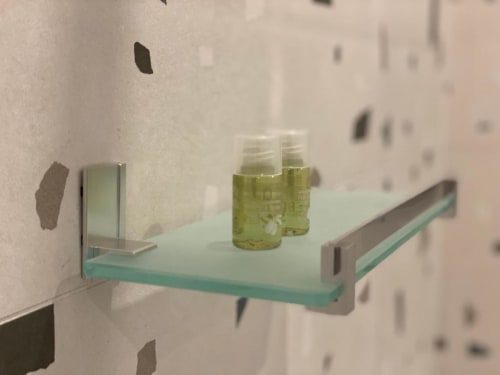 Mensola in vetro del bagno con articoli da toilette verdi presso l'Apartment Mas Collection Superior a Bari
