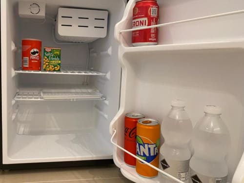 Frigorifero compatto nell'Apartment Superior della Mas Collection a Bari, fornito di bevande e snack tra cui birra Peroni e