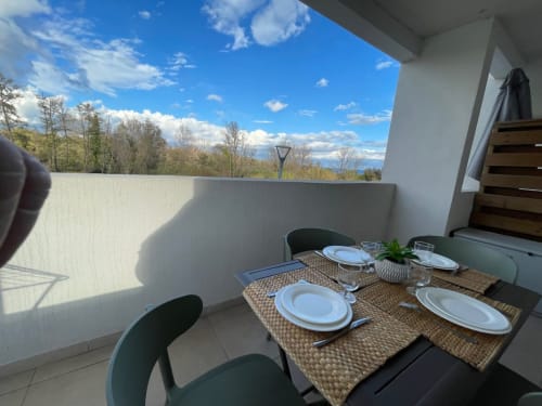 Outdoor terrace at Résidence Marina di Bravone with set dining table, mountain views, and clear sky in Linguizzetta, Corsica