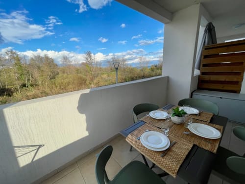 Balcony dining table at Résidence Marina di Bravone, Linguizzetta, overlooking forest and mountains