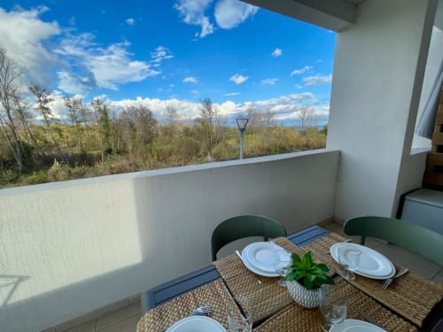Balcony dining at Résidence Marina di Bravone with mountain and forest views, Linguizzetta