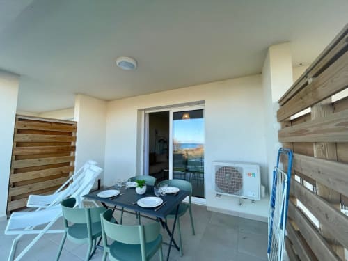 Marina di Bravone apartment terrace with dining table, sea view, loungers, and beach access in Linguizzetta