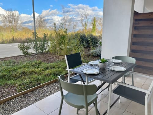 Terrazza fronte mare a Marina di Bravone con tavolo da pranzo, sedie moderne e vista sul giardino