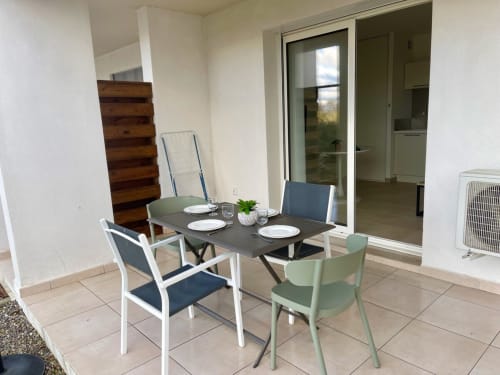 Accogliente zona pranzo dell'appartamento T2 a Résidence Marina di Bravone, Linguizzetta, con tavolo moderno, sedie e accesso alla terrazza