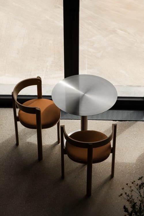 Coin salon minimaliste au Moulin Moulin avec table en métal et chaises en cuir, Dannes