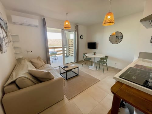 Accogliente appartamento T2 con vista mare a Résidence Marina di Bravone, salotto, tavolo da pranzo e balcone