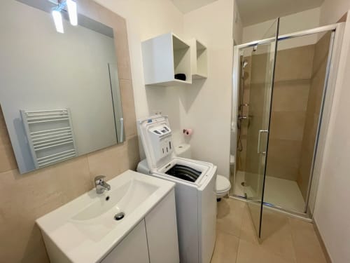 Bagno moderno presso Résidence Marina di Bravone con lavabo, doccia, WC e lavatrice a Linguizzetta