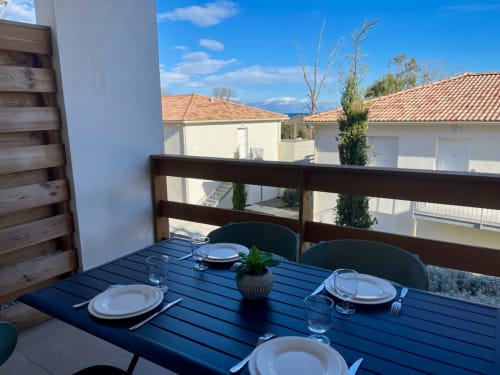 Zona pranzo in balcone presso Résidence Marina di Bravone, Linguizzetta con vista sul mare e edifici limitrofi