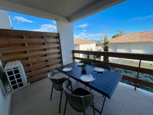 Zona pranzo in balcone presso Résidence Marina di Bravone, Linguizzetta, con tavolo apparecchiato affacciato sulla spiaggia