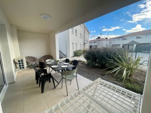 Terrazza coperta con tavolo da pranzo e sedie con vista sui giardini di Marina di Bravone, Linguizzetta