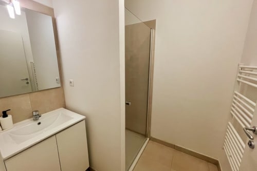Bagno moderno presso la Résidence Marina di Bravone con lavabo bianco, specchio e doccia a Linguizzetta