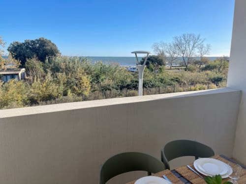 Seaside terrace at Résidence Marina di Bravone with sea view, dining setup, and Corsican coast landscape