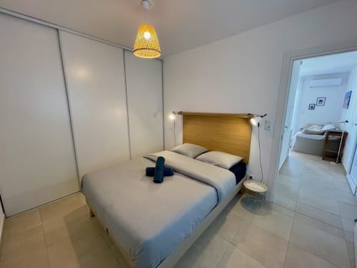 Modern bedroom at Résidence Marina di Bravone with wooden headboard, white bedding, and sliding wardrobe in Linguizzetta