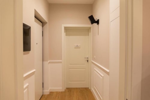 Ingresso moderno della Pink Room presso l'appartamento Mas Collection Bari con pareti color crema e pavimenti in legno