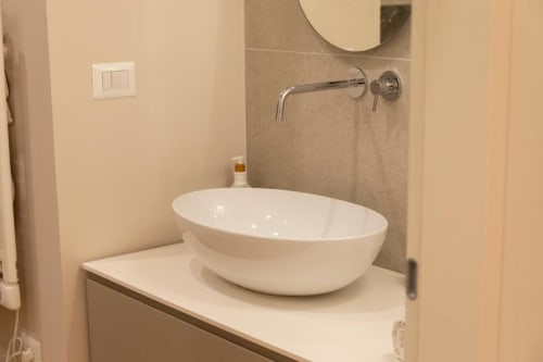 Lavabo ovale bianco moderno con rubinetto a parete nella bathroom della Mas Collection Pink Room a Bari
