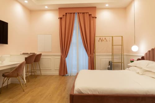 Camera elegante nella Mas Collection Bari con letto queen, tende color terracotta, scrivania e comfort moderni