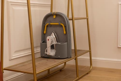 Asse da stiro grigia con ferro bianco nell'appartamento beige della Mas Collection a Bari, Italia