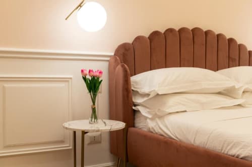 Camera da letto moderna nella Pink Room di Mas Collection a Bari con testata in terracotta, biancheria crema e tulipani rosa su marmo