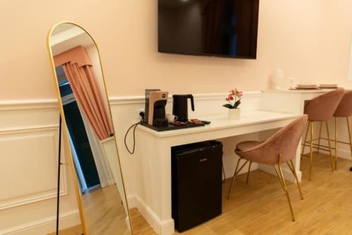Spazioso angolo di lavoro in appartamento con scrivania, specchio, macchina da caffè e sedute confortevoli nella Pink Room di Mas Collection a Bari