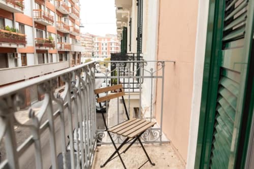 Balcone accogliente con sedia in legno che si affaccia sulla strada di Bari nell'appartamento Mas Collection