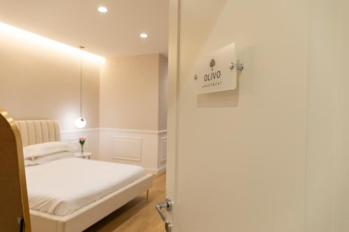 Camera moderna beige all'Olivo Apartment di Bari con parete specchiata, letto color crema e illuminazione ambientale