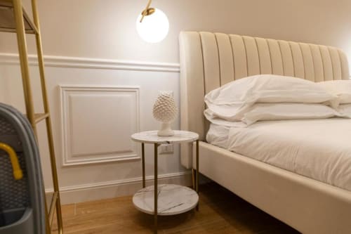 Camera da letto beige Mas Collection a Bari con testata imbottita, tavolino in marmo e lampada a sospensione