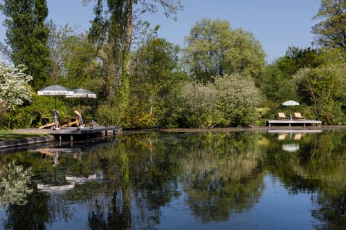 Jardin en bord d'eau du Moulin Moulin B&B à Dannes, avec embarcadère, parasols et chaises longues